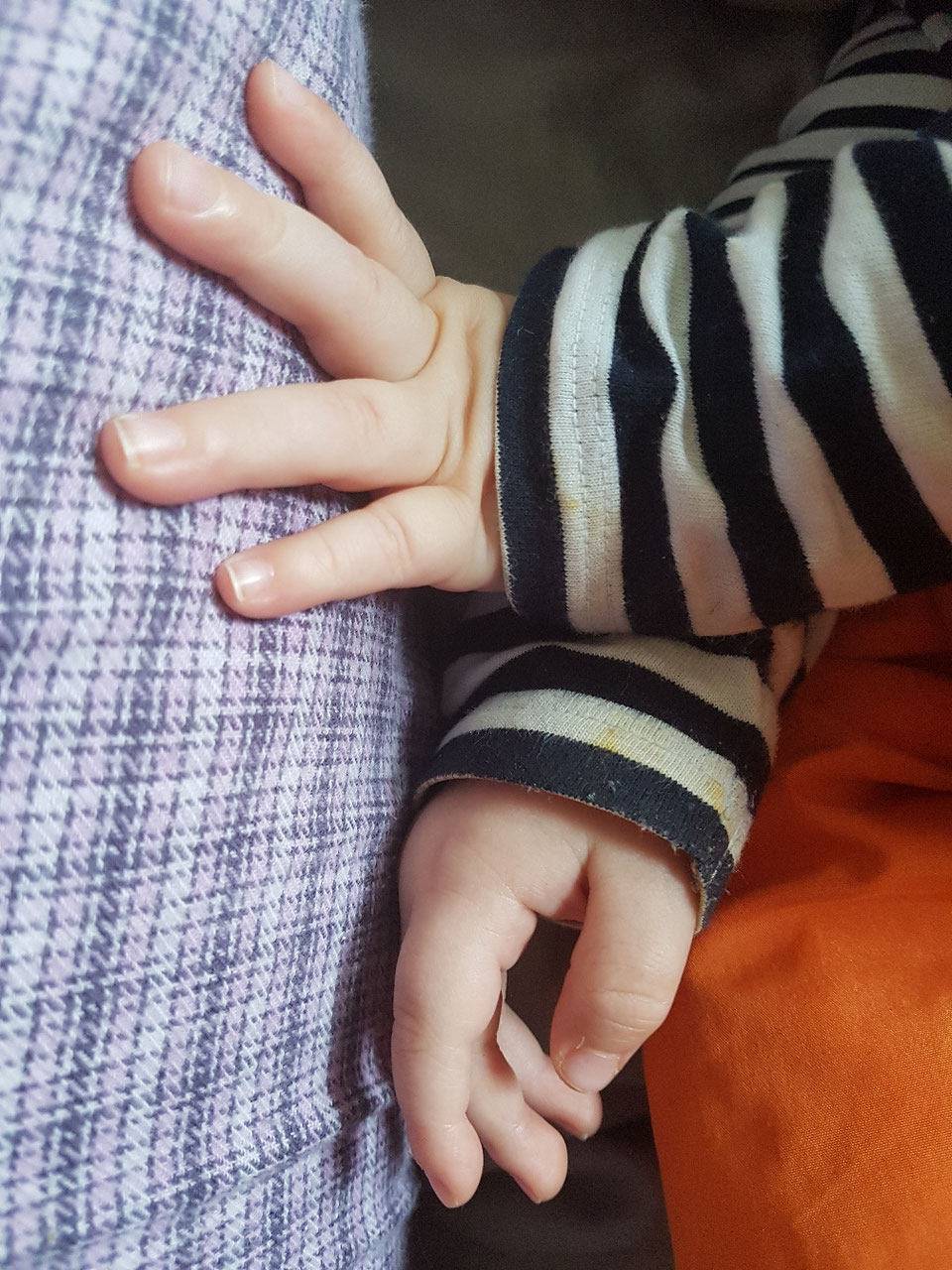 Babyhand berührt das Bein seiner Mama. Symbolbild zum Brief zum ersten Geburtstag auf Mama-Blog Patschehand.de.